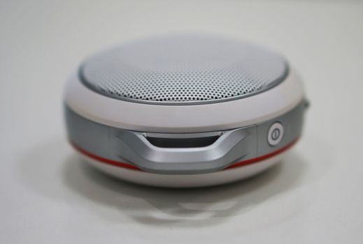 Round-shape portable loudspeaker, has button to decrease or increase the volume.                               