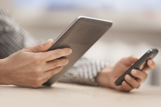 Businesswoman at office with digital tablet and smartphone