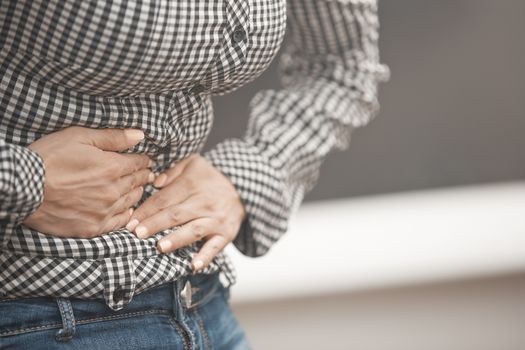 Close-up view on the woman torso suffering of stomach ache