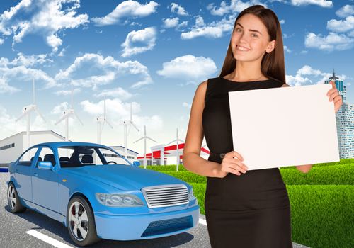Smiling young businesswoman holding blank paper on nature background with blue car