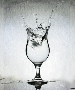 
Ice cubes splashing into glass of water, motion blur