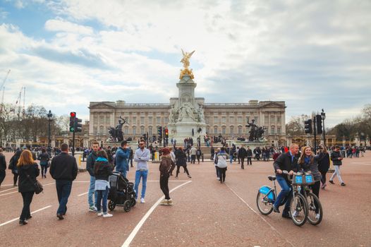 LONDON - APRIL 5: Buckingham palace with crowd of tourists on April 5, 2015 in London, UK. It's the London residence and principal workplace of the monarchy of the United Kingdom.