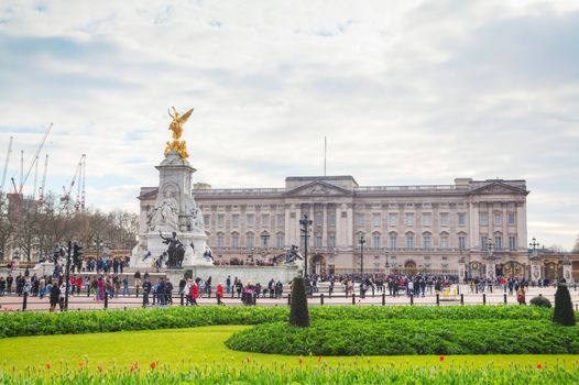 LONDON - APRIL 5: Buckingham palace with crowd of tourists on April 5, 2015 in London, UK. It's the London residence and principal workplace of the monarchy of the United Kingdom.