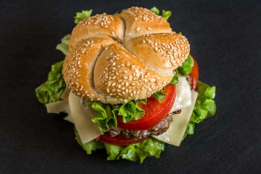 Closeup of Homemade Hamburger with Fresh Vegetables on Stone Background