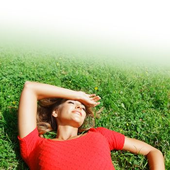 beautiful young woman in red dress lying on grass