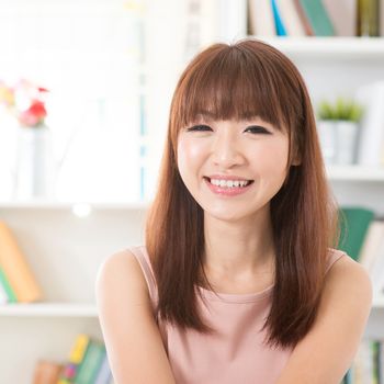 Portrait of Asian woman relaxed and laughing at home, female living lifestyle indoors.