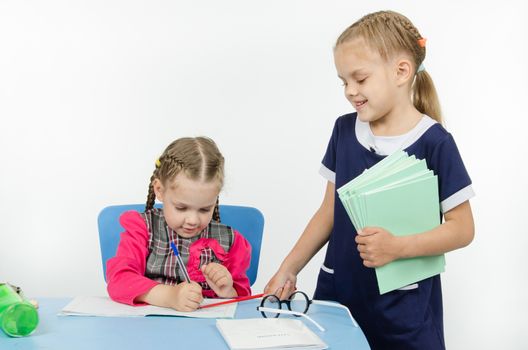 Two girls play school teacher and student