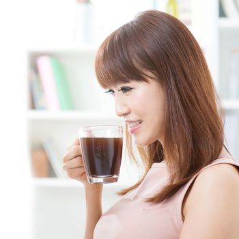 Portrait of attractive Asian girl enjoying cup of hot coffee in the morning. Young woman indoors living lifestyle at home.