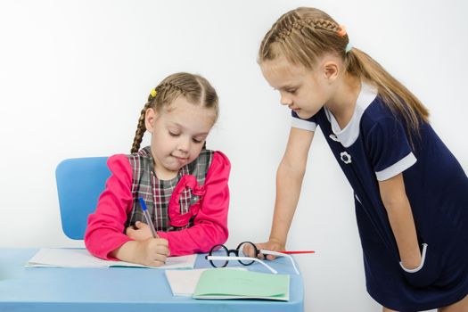 Two girls play school teacher and student