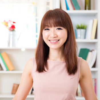 Portrait of Asian woman smiling at home, female living lifestyle indoors.