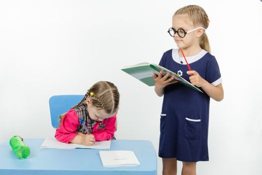 Two girls play school teacher and student