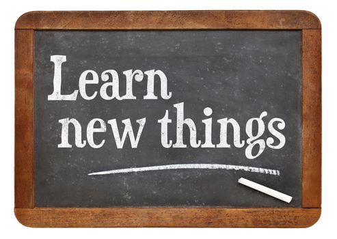 Learn new things - motivational text on an isolated  vintage slate blackboard