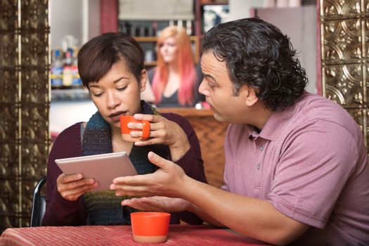 Woman distracted with tablet while man tries talking to her