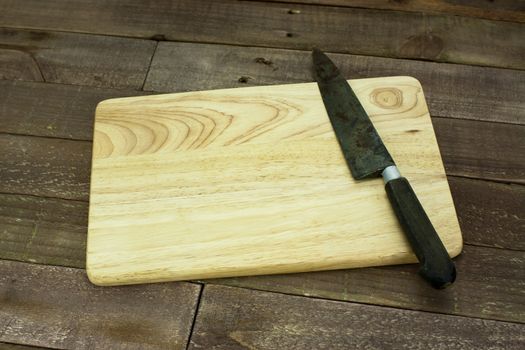 Wooden chopping board with an old knife