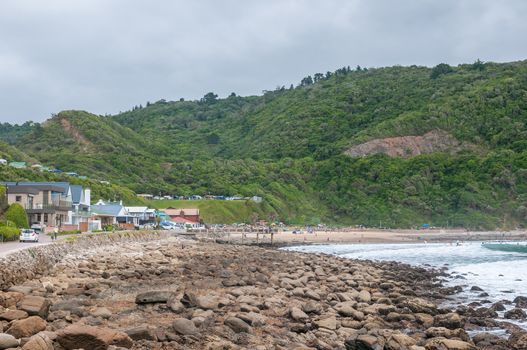 GEORGE, SOUTH AFRICA - JANUARY 4, 2015: Unidentified people, holiday homes and a caravan park at Victoria Bay, South Africa at low tide