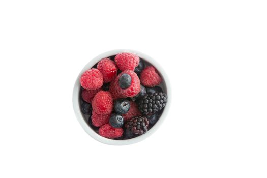 Ramekin of fresh fall or autumn berries with whole juicy ripe blueberries, blackberries and raspberries for a healthy breakfast, snack or dessert or to be used as cooking ingredients, overhead view