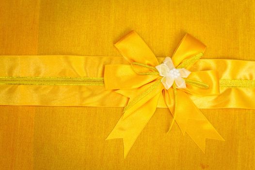 Abstract ribbon bow on fabric background. 