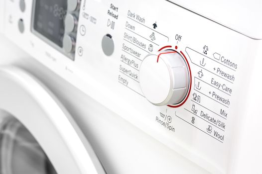 closeup of new white laundry or washing machine, selective focus on control elements