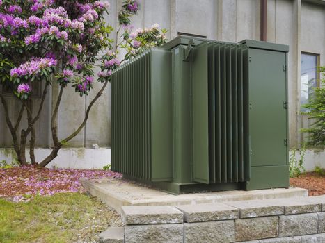 Industrial power transformer on the side of an commercial building