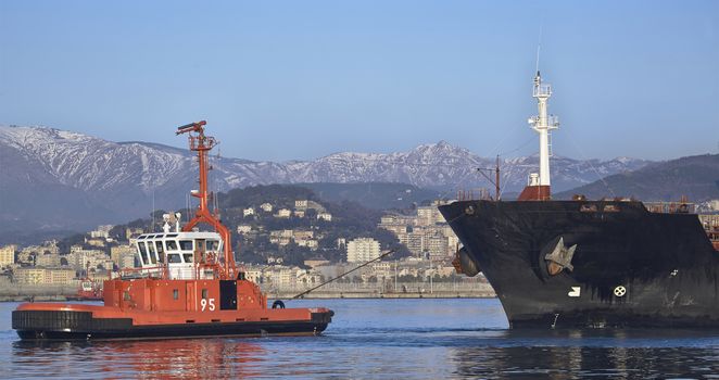 tugs at working near a ship in Genoa oil harbor, Italy