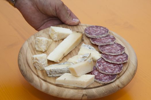 Mixed cheeses wooden platter and salami, italian food