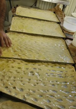 preparation of typical ligurian salt cake, original italian food, called focaccia