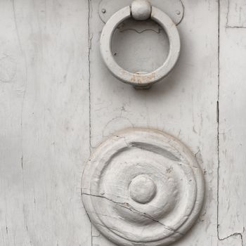 Detail embossed metal handle and an old door