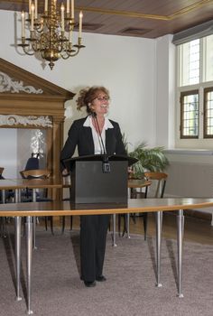 HELLEVOETSLUIS,HOLLAND-JUNE 13,2015:Woman speaking to public behind the desk in the city hall on June 13, Hellevoetsluis,the city hall is a very old room used for weddings