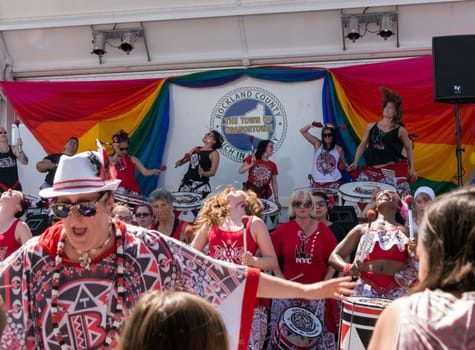 Nyack, NY, USA - June 14, 2015: Members of Batala NYC with leader on the front performing before the stage during Rockland County Pride.