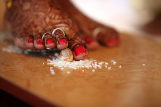 The last steps of the bride among the 7 taken during a traditional hindu religious wedding consisting of a betelnut and rice.