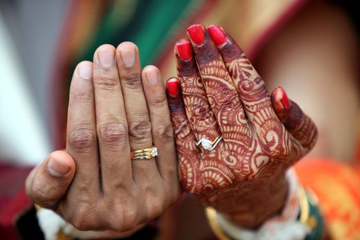 The wedding rings on the hands of an Indian bride and groom