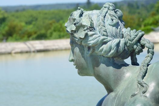 Sculpture of womans head overlooking fountain
