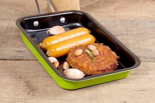 pork fried and  sausages in pan 