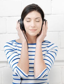 technology and music concept - picture of happy teenage girl in big headphones