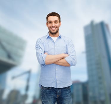 happiness and people concept - smiling man with crossed arms