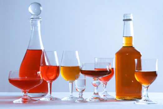 Alcohol conceptual image. Glasses and bottle of wine and whisky on isolated background.