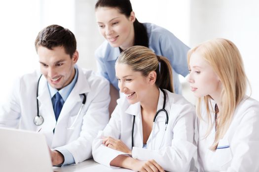 healthcare, medical and technology concept - group of doctors looking at laptop