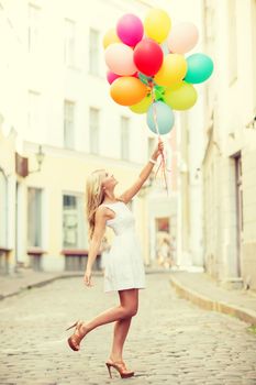 summer holidays, celebration and lifestyle concept - beautiful woman with colorful balloons in the city