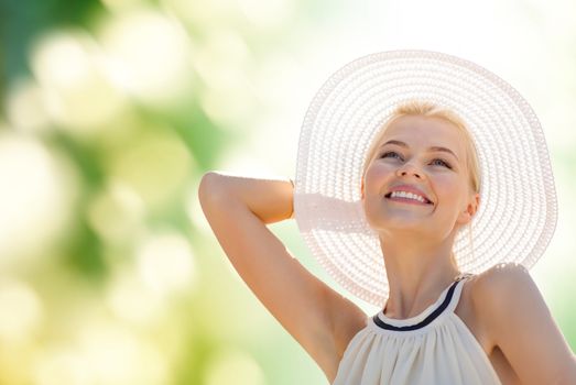 fashion, happiness and lifestyle concept - beautiful woman in hat enjoying summer outdoors