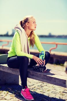 sport and lifestyle concept - woman resting after doing sports outdoors