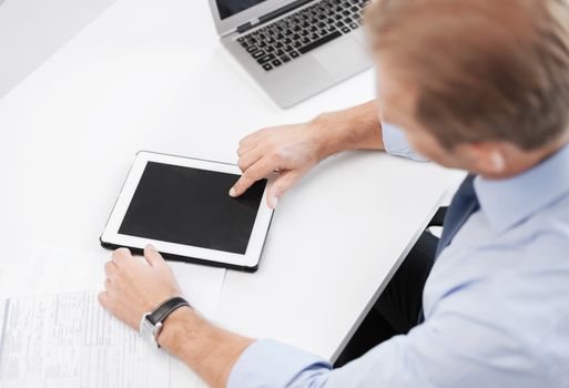 business and technology concept - businessman with tablet pc in office