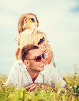 summer holidays, children and people concept - happy family with blue sky and green grass