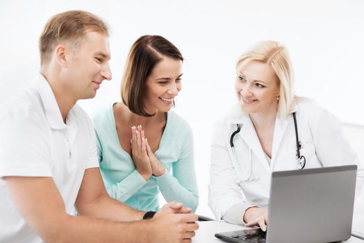 healthcare, medical and technology - doctor with patients looking at laptop