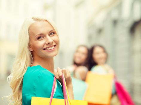 sale, shopping, tourism and happy people concept - beautiful woman with shopping bags in the ctiy