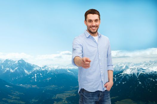 happiness and people concept - smiling man pointing finger at you