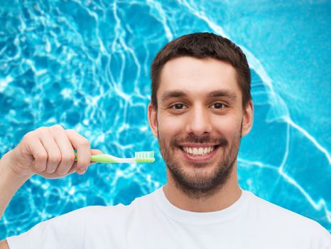 health and beauty concept - smiling young man with toothbrush