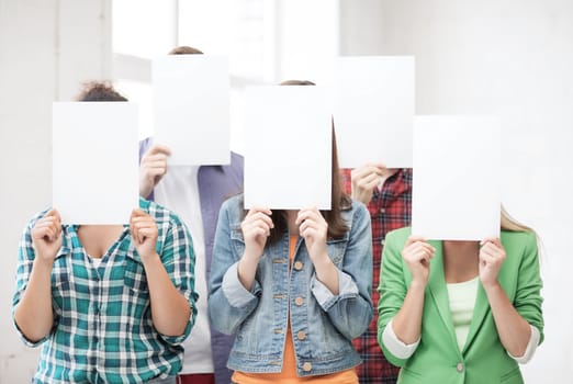 education concept - group of students covering faces with blank papers