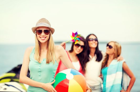 summer holidays, vacation and beach activities - girl with ball and friends on the beach