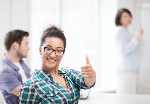 education concept - african student girl showing thumbs up at school