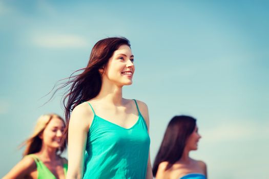 summer holidays and vacation - girl with friends walking on the beach